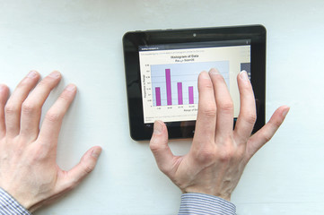 businessman holding a tablet computer with graphics on screen
