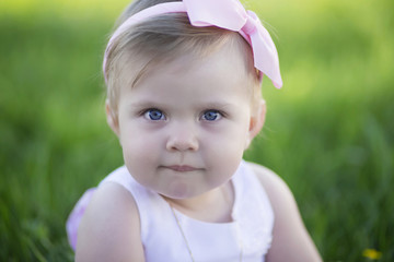 Closeup portrait of baby girl on green grass background
