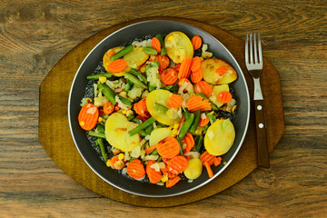 Steamed vegetables potatoes, carrots, corn, green beans and onio