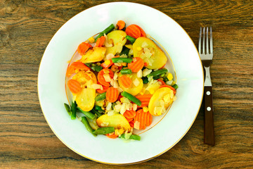 Steamed vegetables potatoes, carrots, corn, green beans and onio