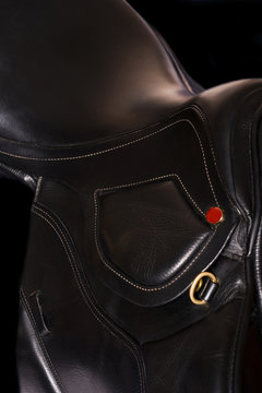 Black leather professional saddle  at black background