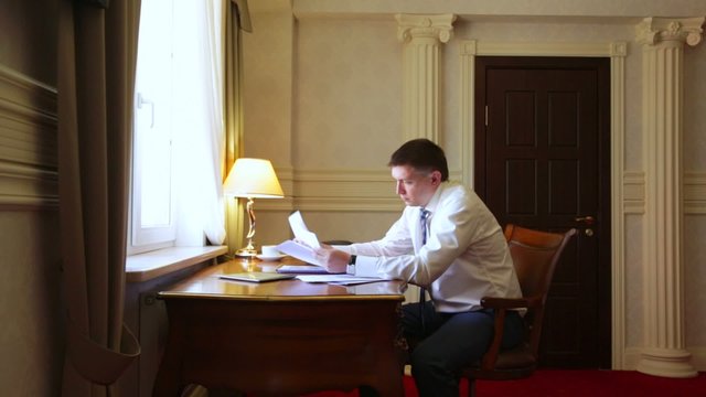 Businessman working with documents in the hotel room