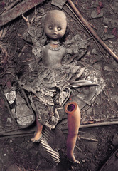 muñeca diabolica tumbada sobre tierra