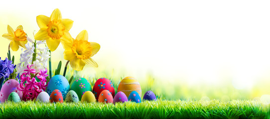 Daffodils Hyacinths And Decorated Eggs On Green Meadow - Easter Holiday Background
