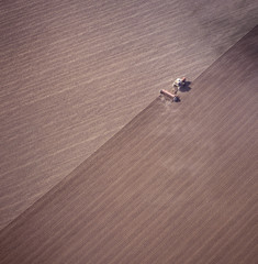 Obraz premium Aerial view of tractor ploughing a paddock in the far west of NSW getting ready for a wheat crop.