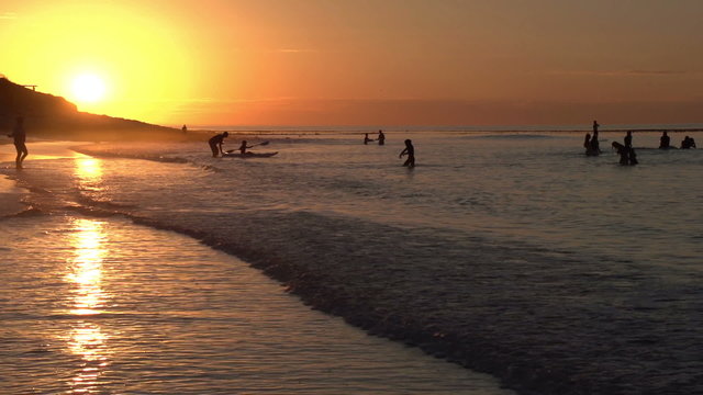 People playing on beach in shallow water in silhouette,Cape Town,South Africa