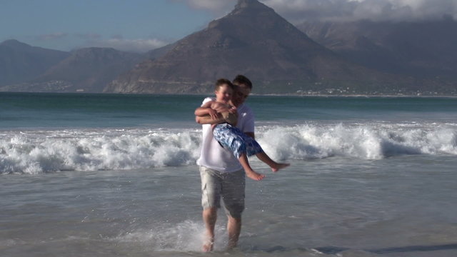 Couple with child playing in the waves at the beach, Cape Town,South Africa