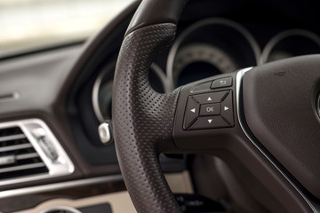Obraz na płótnie Canvas Control buttons on steering wheel. Car interior detail.