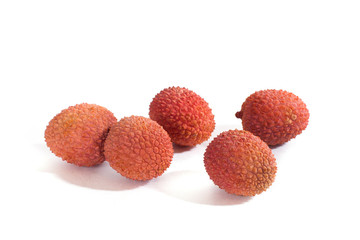 Five lychees lie on white background