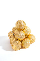 Balls of sweets in golden sweetie paper isolated on white background