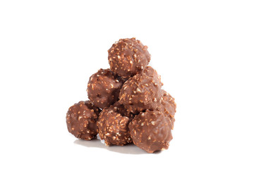 Balls of milk chocolate lie in form of pyramid, isolated on white background