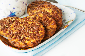 Round cookies with sesame seeds on a blue napkin.