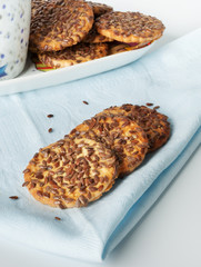 Round cookies with sesame seeds on a blue napkin.