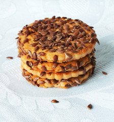 Round cookies with sesame seeds on a blue napkin.