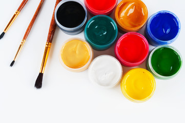 Jars with colored gouache and paint brushes.