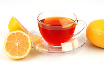Glass cup of tea surrounded by lemons.