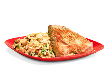 Cooked meal of brown rice and beans with a tuna fish steak on a red plate