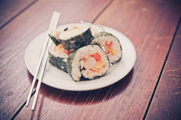 Close up of Rolled sushi rice on a white dish , Dark Vintage color filter