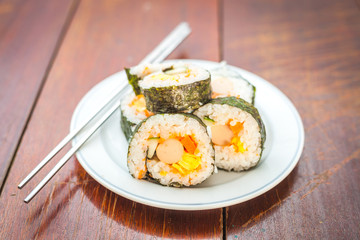 Close up of Rolled sushi rice on a white dish , Dark Vintage color filter