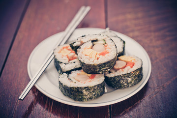 Close up of Rolled sushi rice on a white dish , Dark Vintage color filter