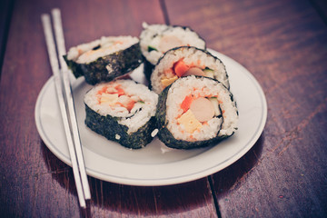 Close up of Rolled sushi rice on a white dish , Dark Vintage color filter