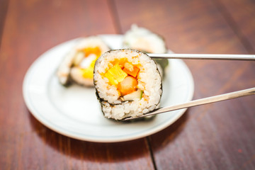 Close up of Rolled sushi rice on a white dish , Dark Vintage color filter