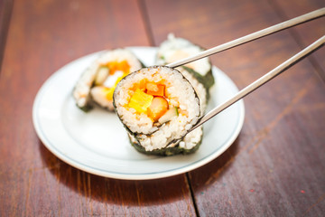 Close up of Rolled sushi rice on a white dish , Dark Vintage color filter