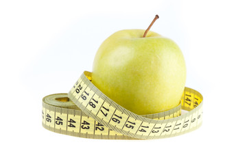 fresh green apple and tape measure isolated on white background