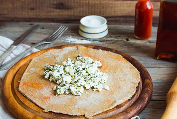 cook rye biscuit with goat cheese and herbs, wooden board,close-