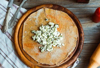 cook rye biscuit with goat cheese and herbs, wooden board