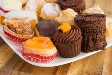 Colourful mini cakes tray on wood