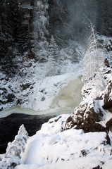 Fototapeta na wymiar Frozen waterfall Kivach in cloudy January day. Karelia, Russia