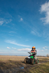 Fototapeta na wymiar Boy rides on electric ATV quad.
