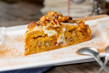 Tasty carrot cake with walnuts on an old wooden table