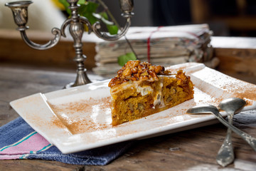 Tasty carrot cake with walnuts on an old wooden table
