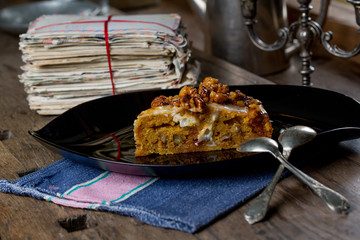 Tasty carrot cake with walnuts on an old wooden table