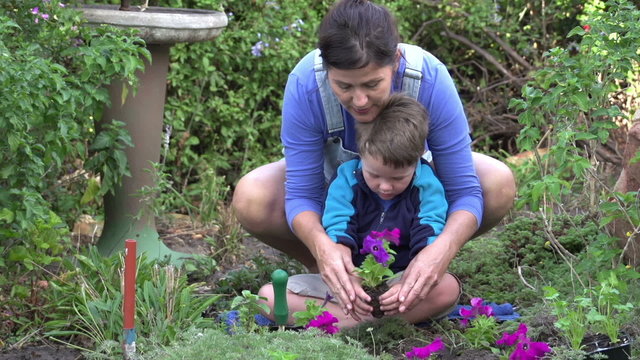 Mother and child planting flower seedlings in the garden, South Africa