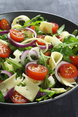 Salad with arugula, cheese, tomato and red onion