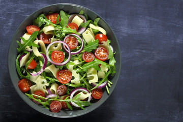 Salad with arugula, cheese, tomato and red onion