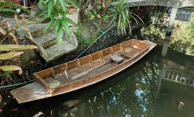 old thai wood  row boat berths in riverside