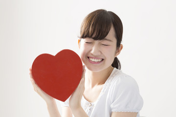 若い女性　ハートを持つ　笑顔　シンプル　汎用