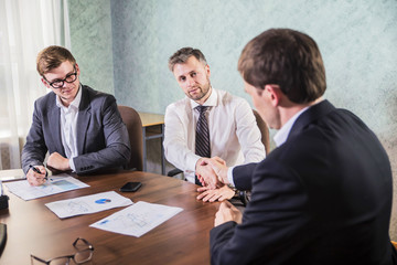businessmen shaking hands during successful negotiations