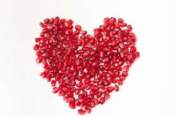 Obraz na płótnie Canvas pomegranate seeds in heart on white background