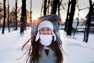 attractive young woman (Girl) playing with snow in warm clothing smiling in the Park