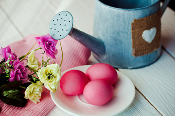 Easter pink Easter background with eggs and flowers on white wooden background