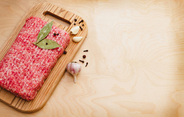 minced meat on a cutting board on a wooden background