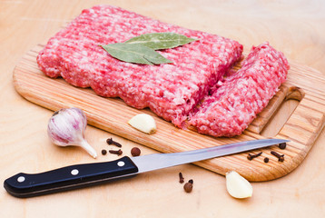minced meat on a cutting board on a wooden background