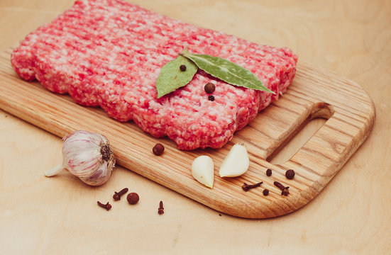 minced meat on a cutting board on a wooden background