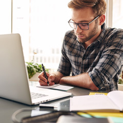 Square shot of a young entrepreneur making notes