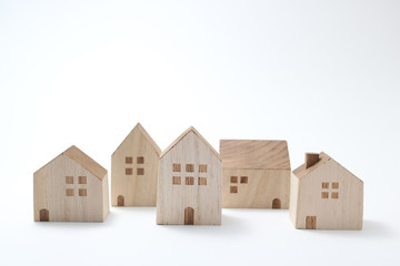 Miniature houses on white background. Building blocks arranged in row.